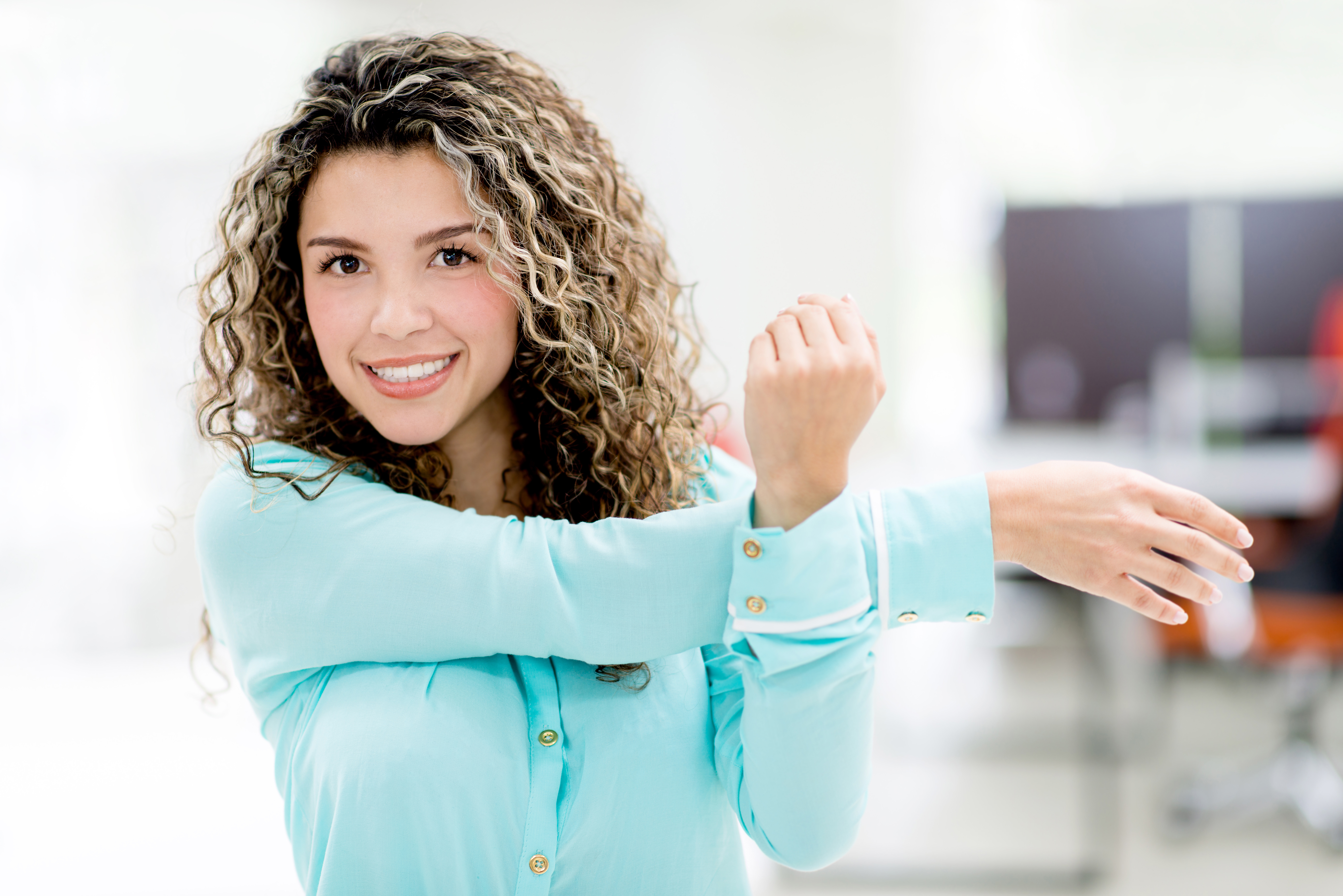 Business woman stretching her arm at the office