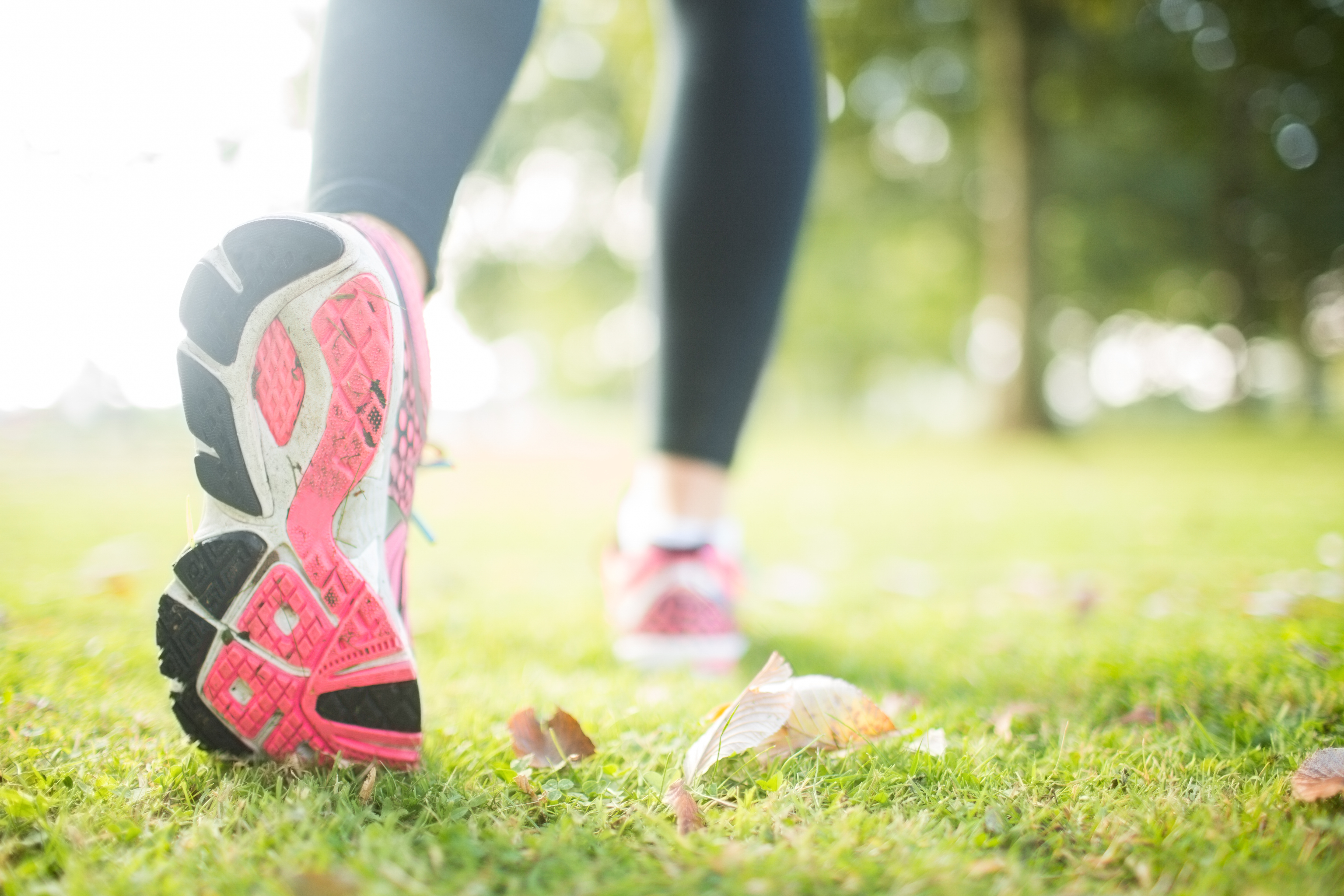 Close up picture of pink sole from running shoe in a park on a sunny d