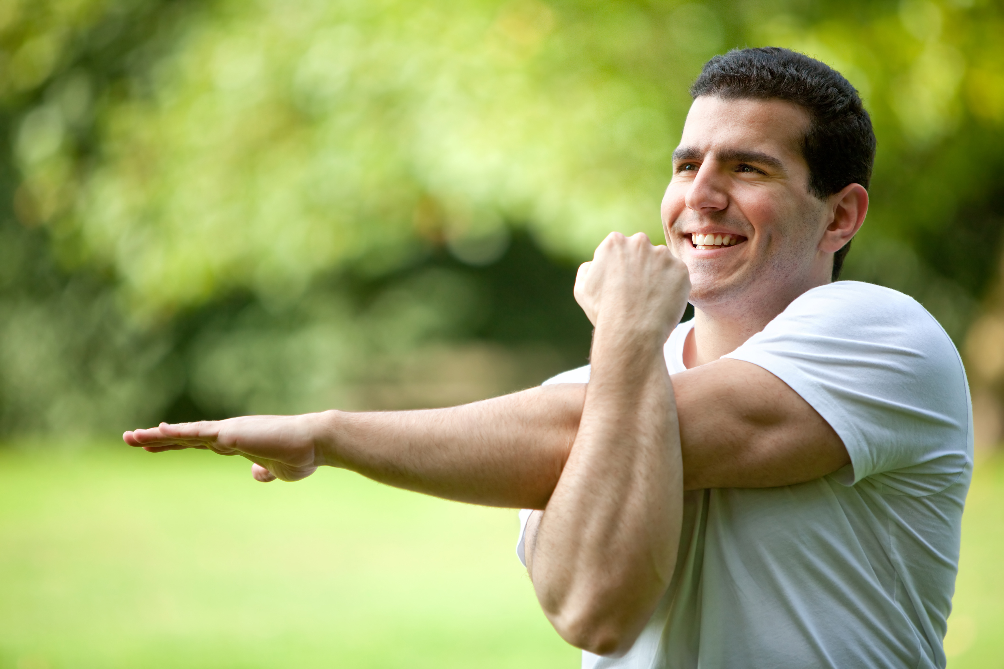 Handsome man stretching at the park - fitness concepts