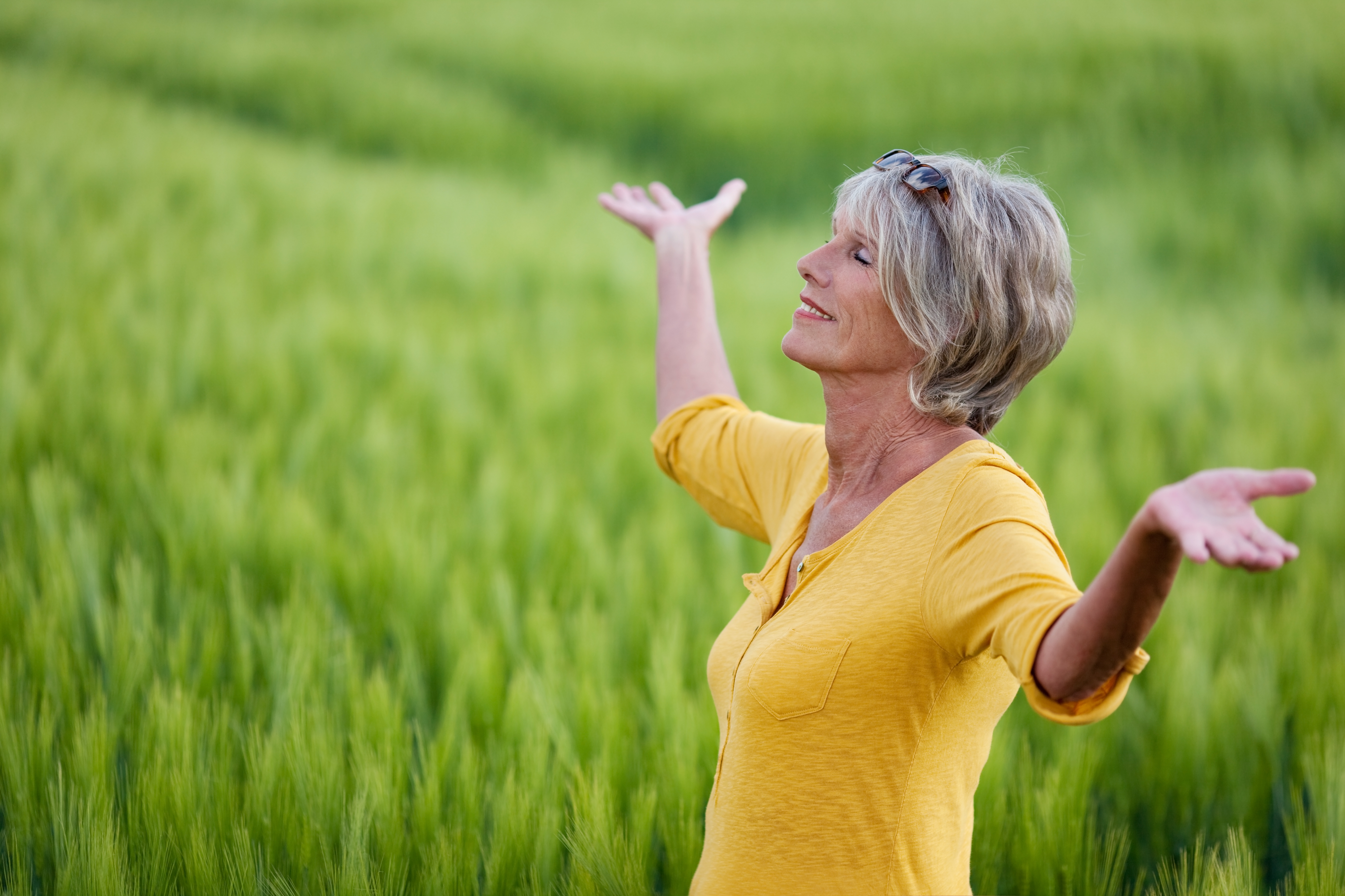 mature woman with outstretched arms in nature